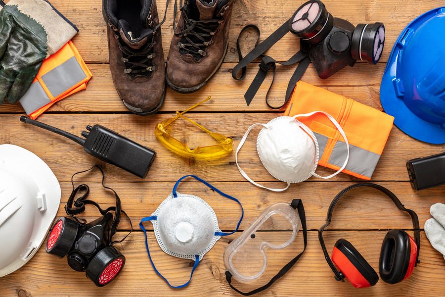 Labor personal protective gear flat lay. Work health and safety for industry and construction site. Protection equipment on wooden background,